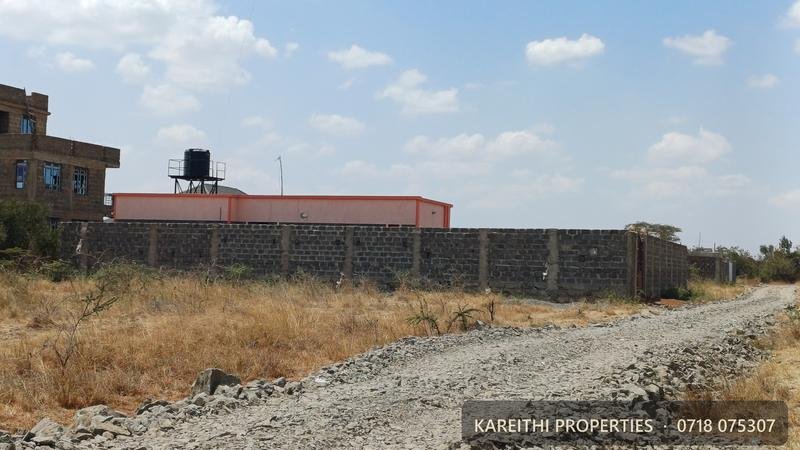 A walled plot in Juja Farm, Mastore, with flats on either side