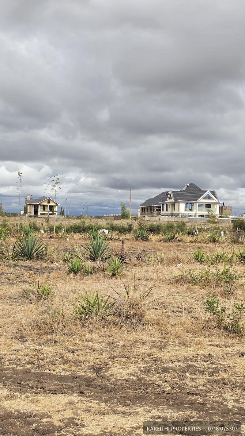 Open land in Juja Farm with a completed home behind it